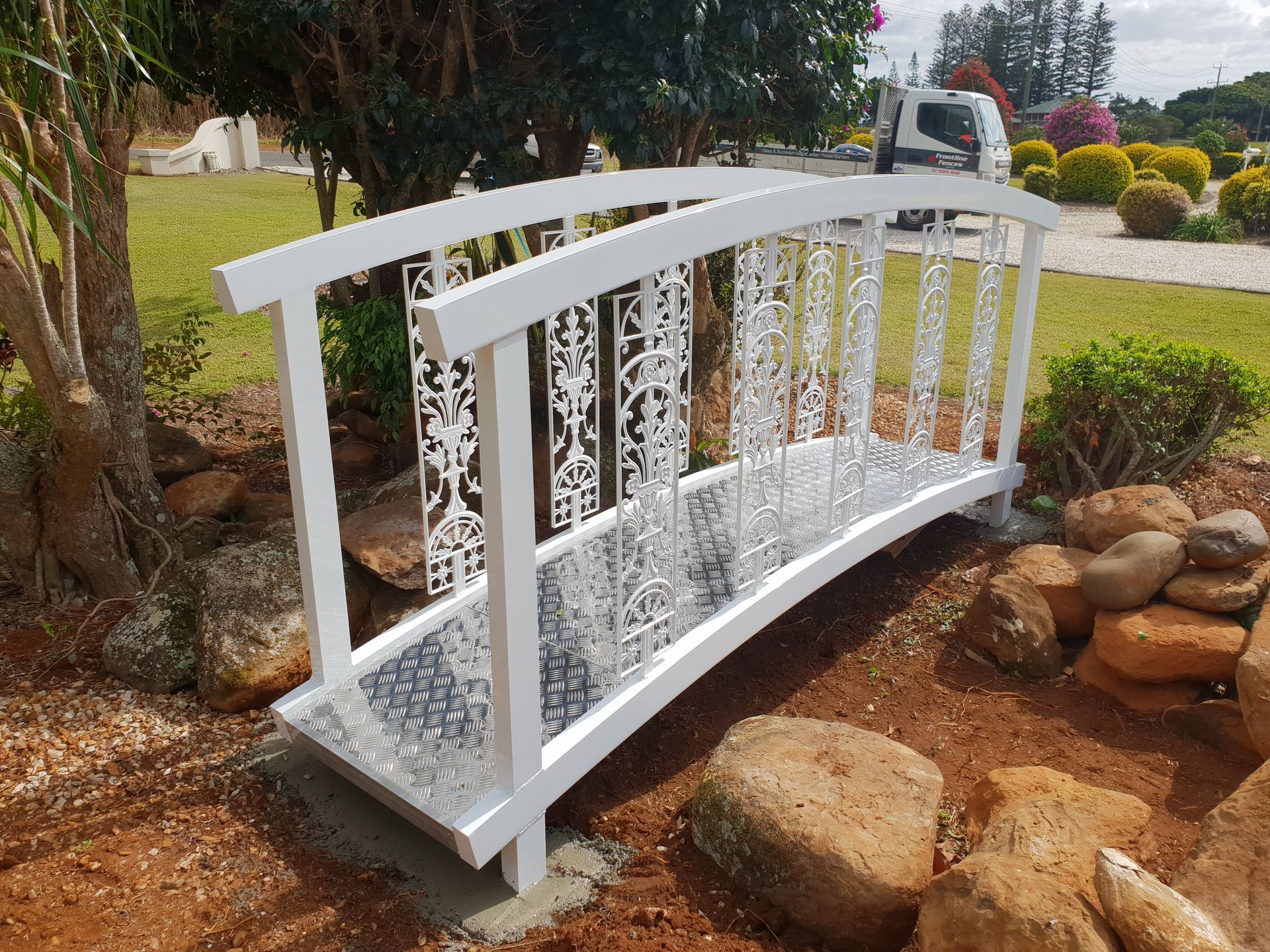 White Decorative Garden Bridge Over a Rocky Landscape in A Landscaped Yard — Frontline Fences in Tweed Heads South, NSW