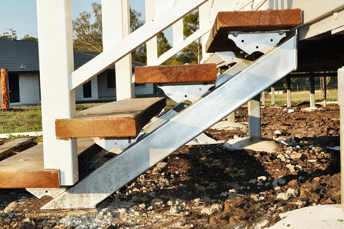 Metal stairs with wooden treads on a gravel foundation under construction
