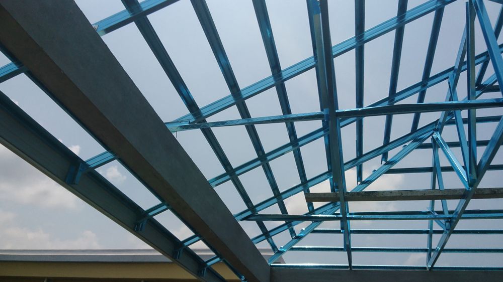 Blue steel roof beams forming a geometric pattern against the sky.