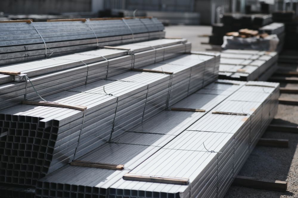 Stacks of silver metal tubing bundled in an industrial yard