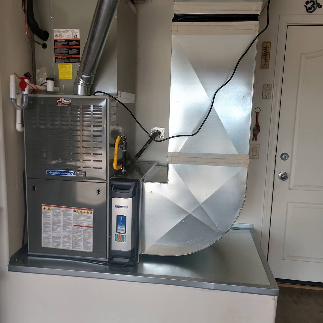 HVAC furnace and ductwork in a utility closet beside a white door
