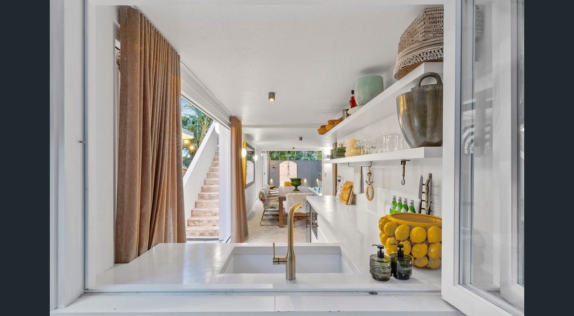 Modern bathroom with round mirror, vessel sink, and white bathtub on gray tiled walls
