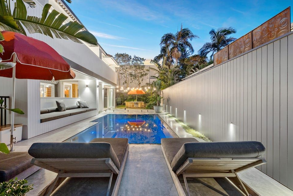 Modern Patio With Lounge Chairs Overlooking a Narrow Blue Pool — Greg Pollard Building in Terranora, NSW
