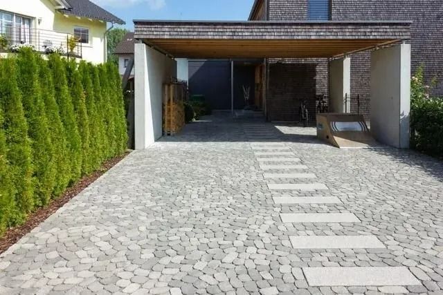 Modern House Driveway With Stone Paving, Hedge on the Left, and a Covered Carport Ahead — Greg Pollard Building in Pottsville, NSW