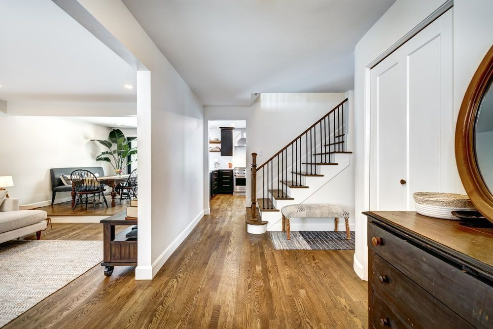 Bright Hallway With Wood Floors, Staircase, and a Glimpse of Dining and Living Spaces on the Left — Greg Pollard Building in Pottsville, NSW