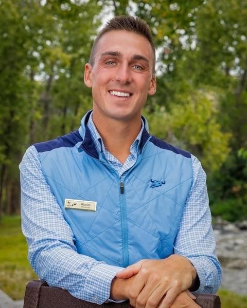 A man wearing a blue vest with a name tag on it