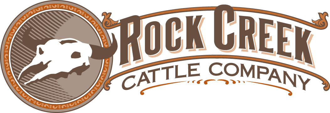 A logo for rock creek cattle company with a cow skull in a circle.