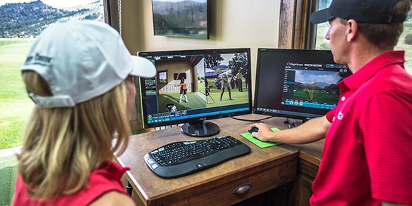 A man and a woman are playing a video game on a computer.