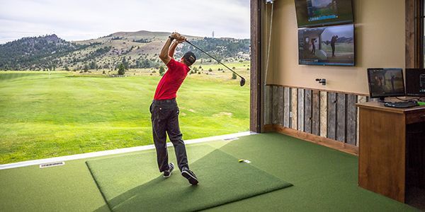 A man is swinging a golf club on a golf course.