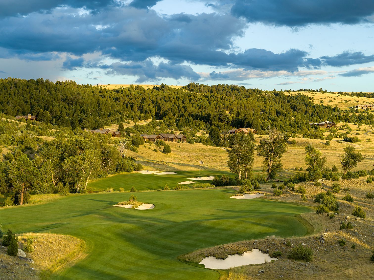An aerial view of a golf course in the middle of a desert.
