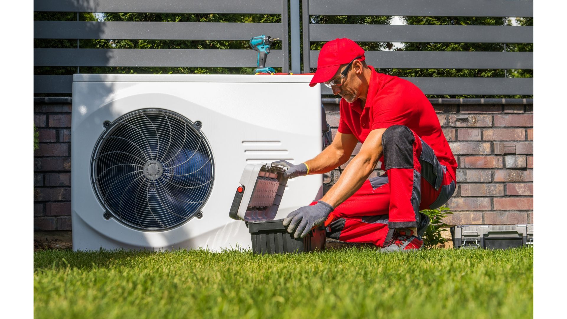 Person in red work clothes, inspecting a heat pump outdoors.