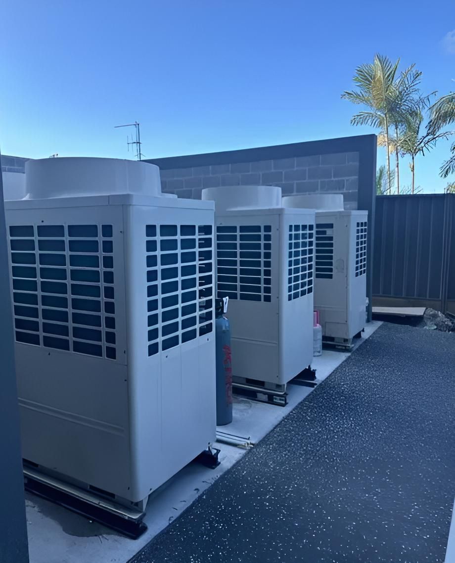 A Row of Air Conditioners Are Sitting Next to Each Other in a Parking Lot — Sparky Mid North Coast In Forster, NSW