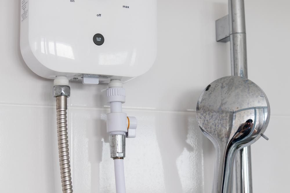 A Close Up of a Shower Head and a Water Heater in a Bathroom — Sparky Mid North Coast In Hallidays Point, NSW
