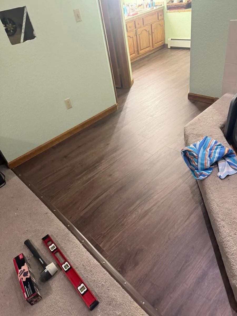 Living room with toy trucks on the floor and a couch with a blue-striped blanket nearby