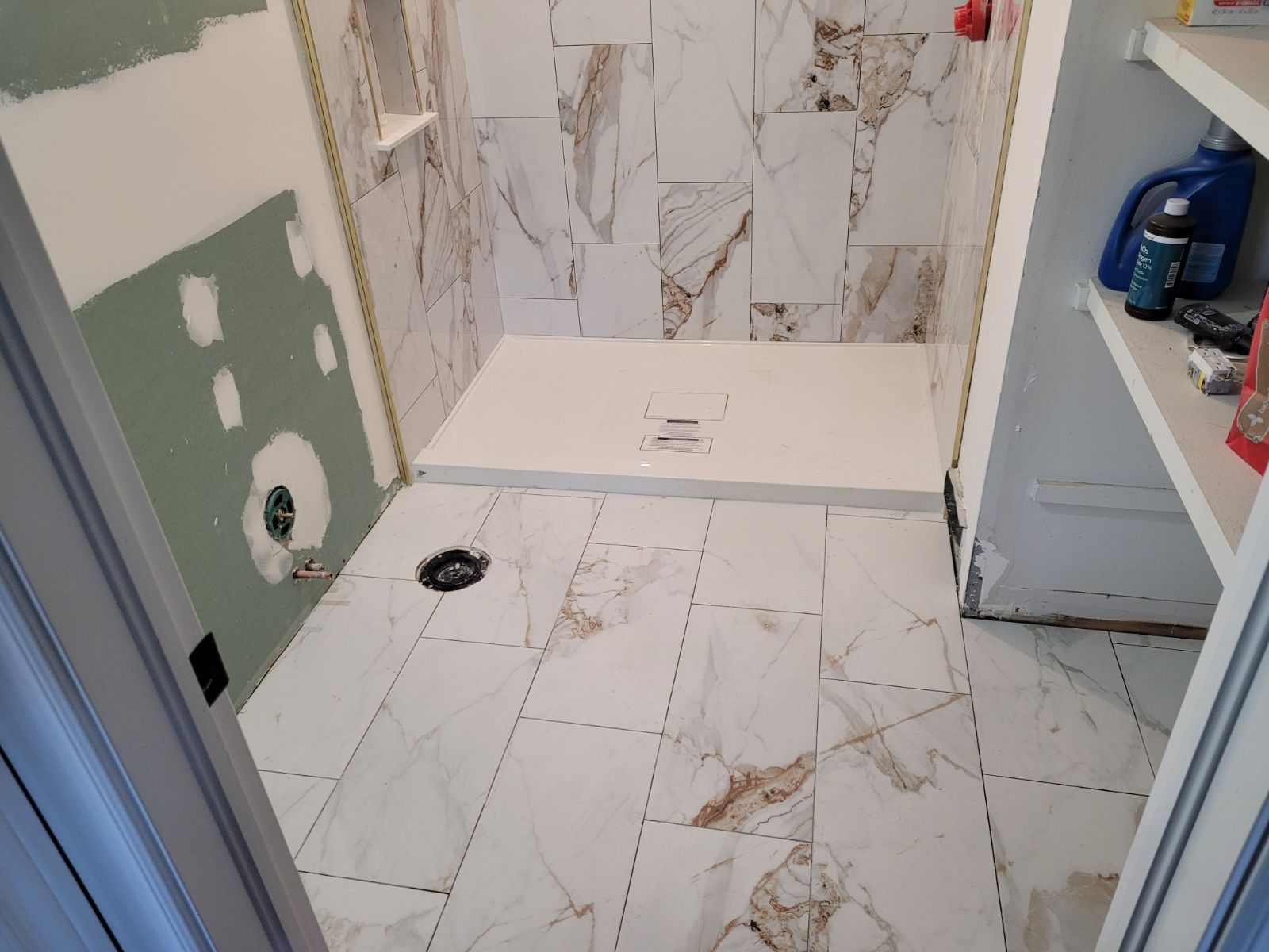 A bathroom under construction with a walk in shower.