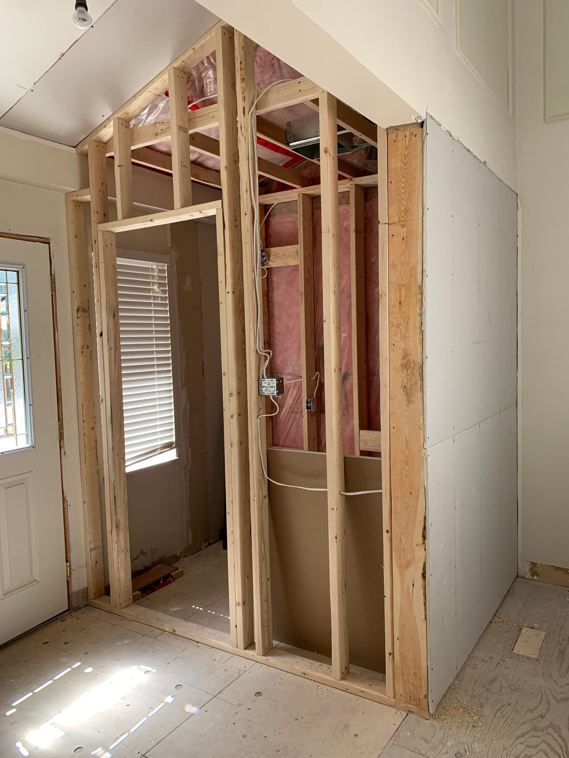 A room with a window and a door is being built.