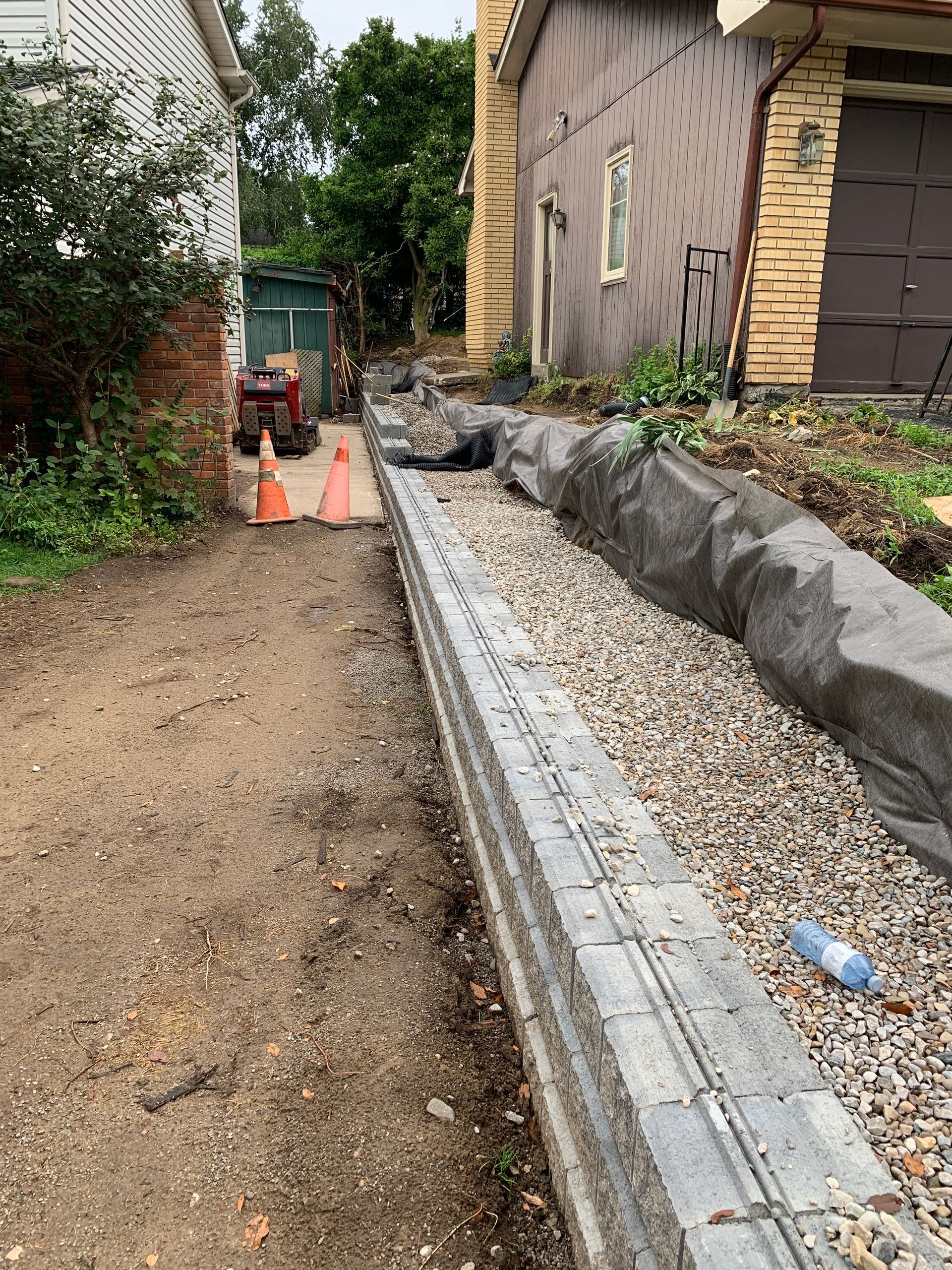 A gravel driveway is being built in front of a house.