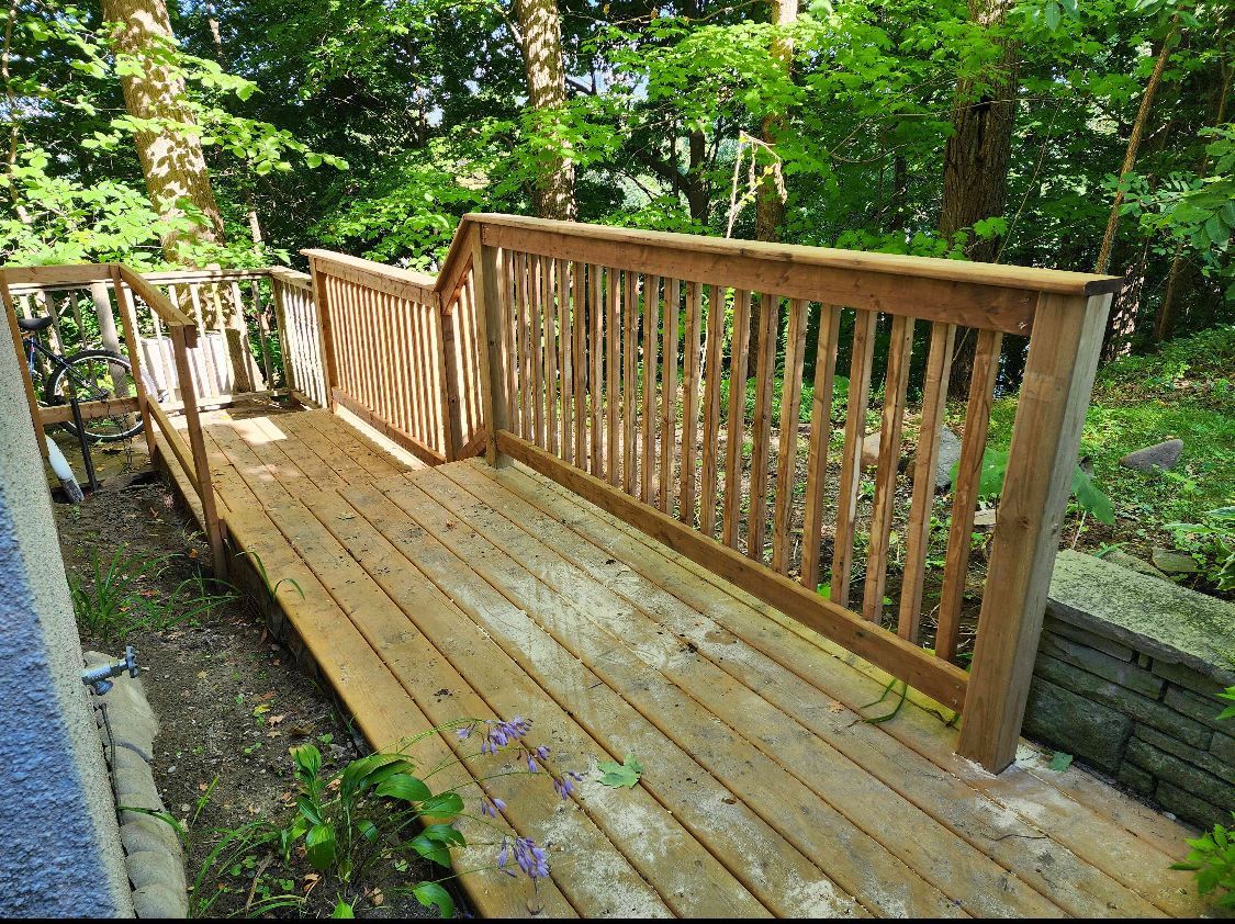 Wooden footbridge with railings in a lush green forest setting