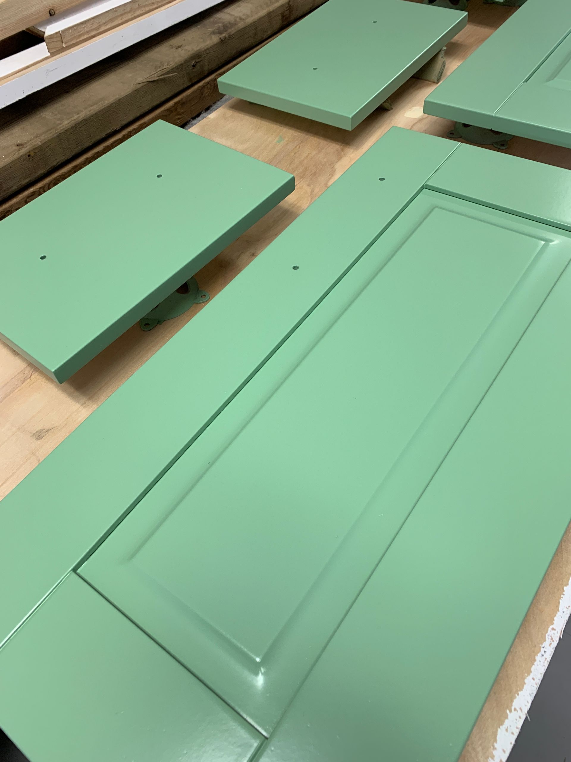 A green door is sitting on top of a wooden table.