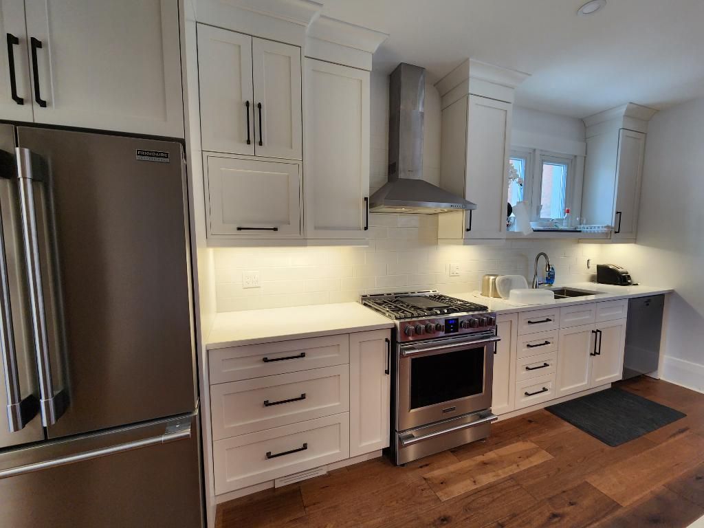 A kitchen with white cabinets and stainless steel appliances.