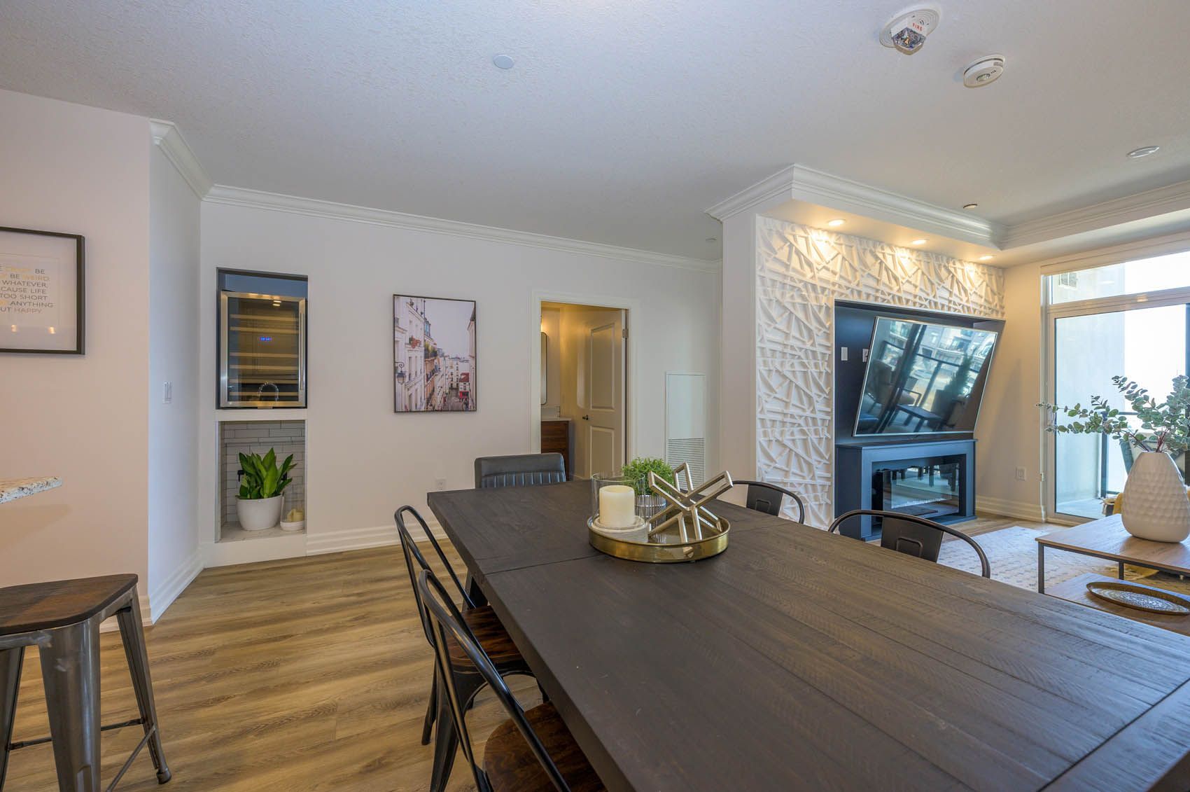 A living room with a dining table and chairs and a television.