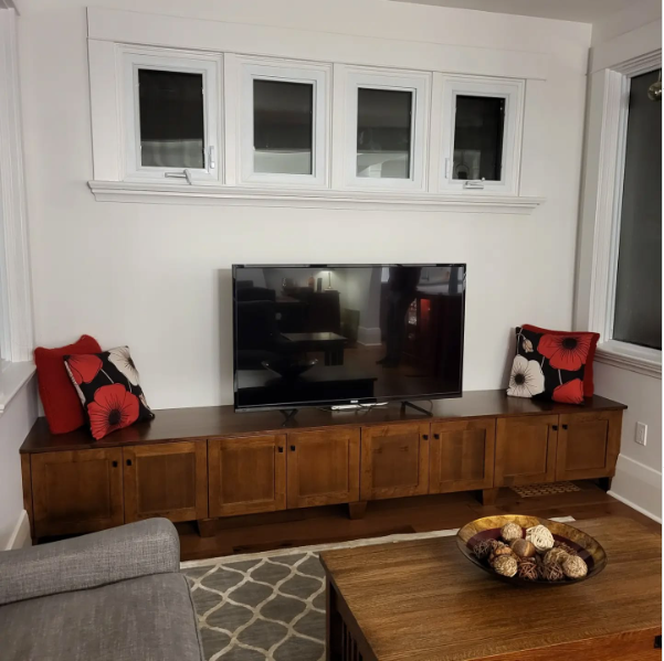 A living room with a flat screen tv on a wooden entertainment center