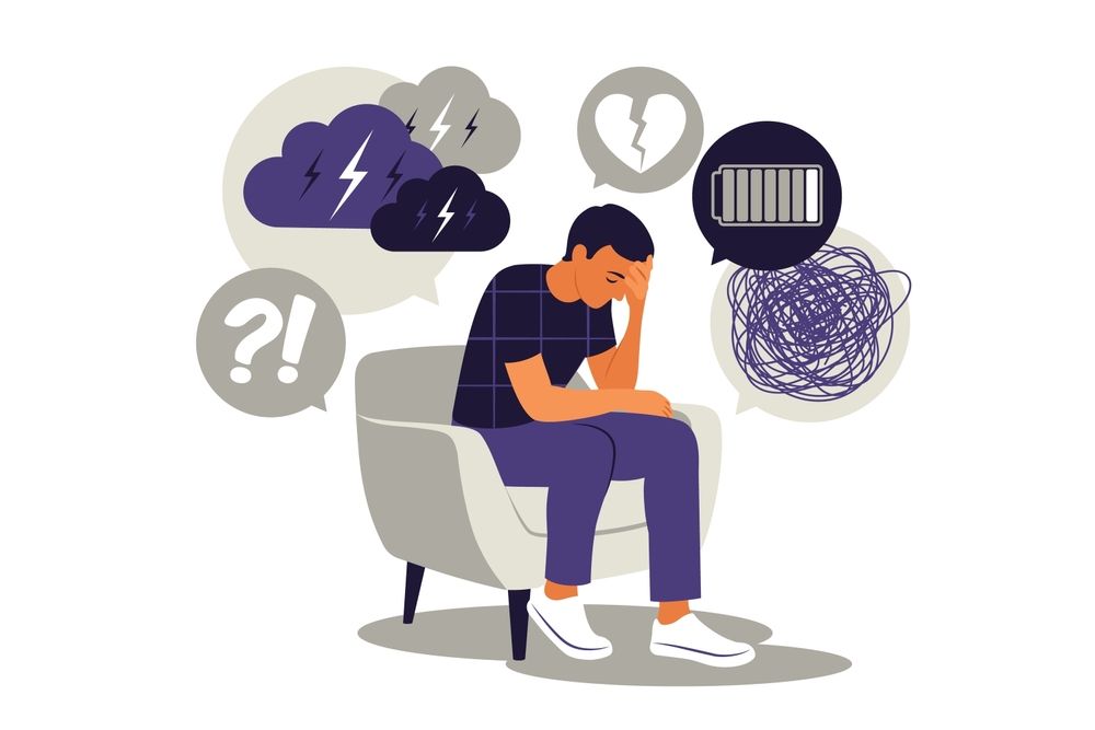 a man is sitting in a chair with his head in his hands