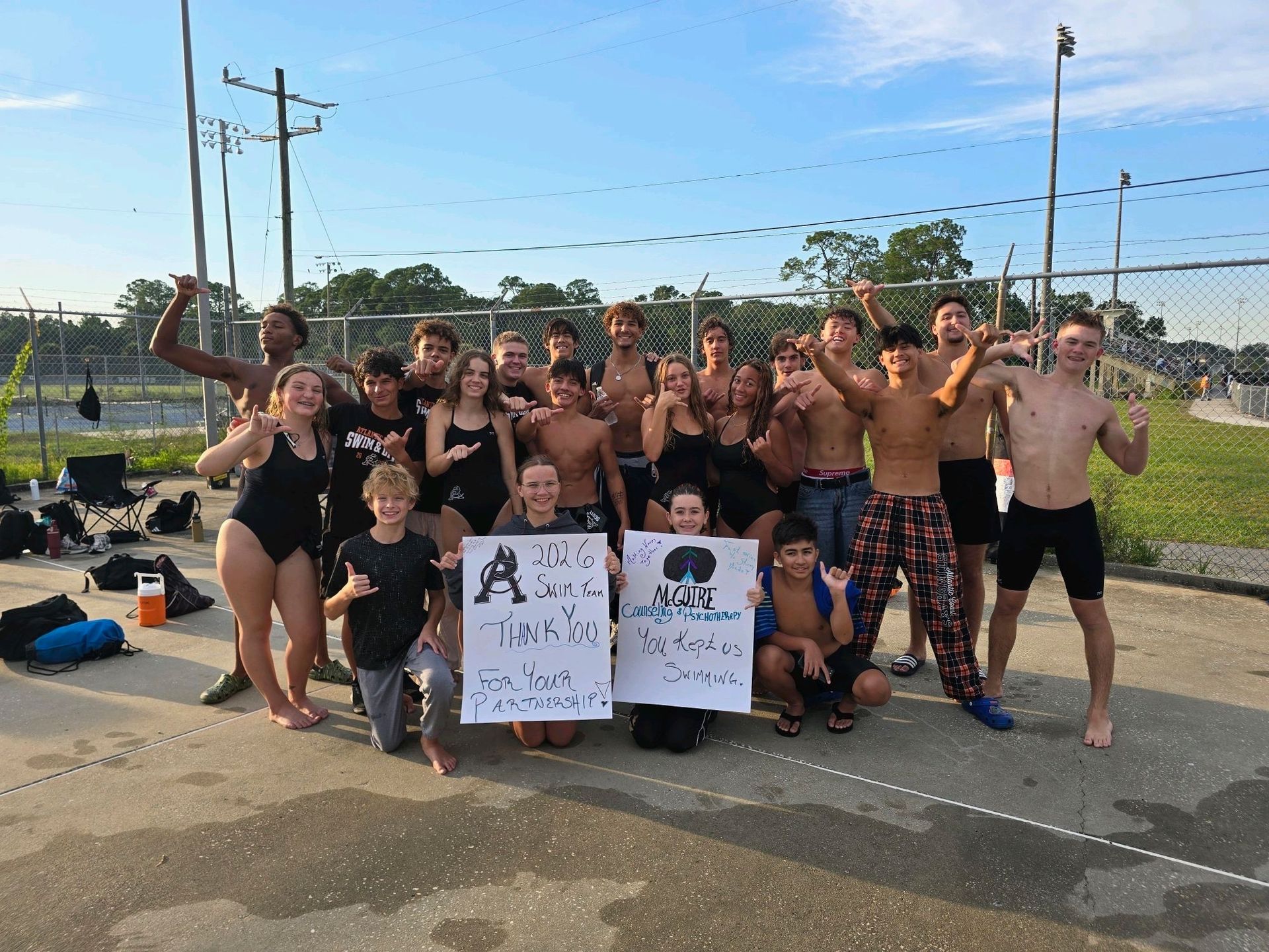 Atlantic Coast swim team wi thank-you signs for McGuire Counseling & Psychotherapy in Jacksonville