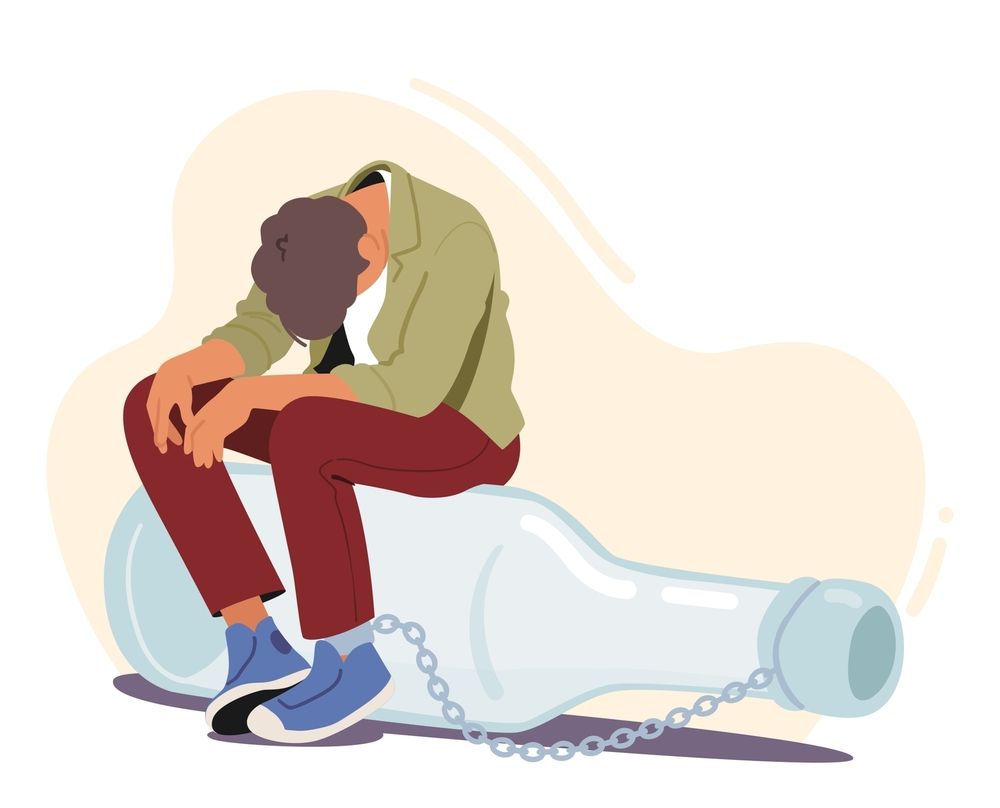A man is sitting on top of an empty bottle chained to it.