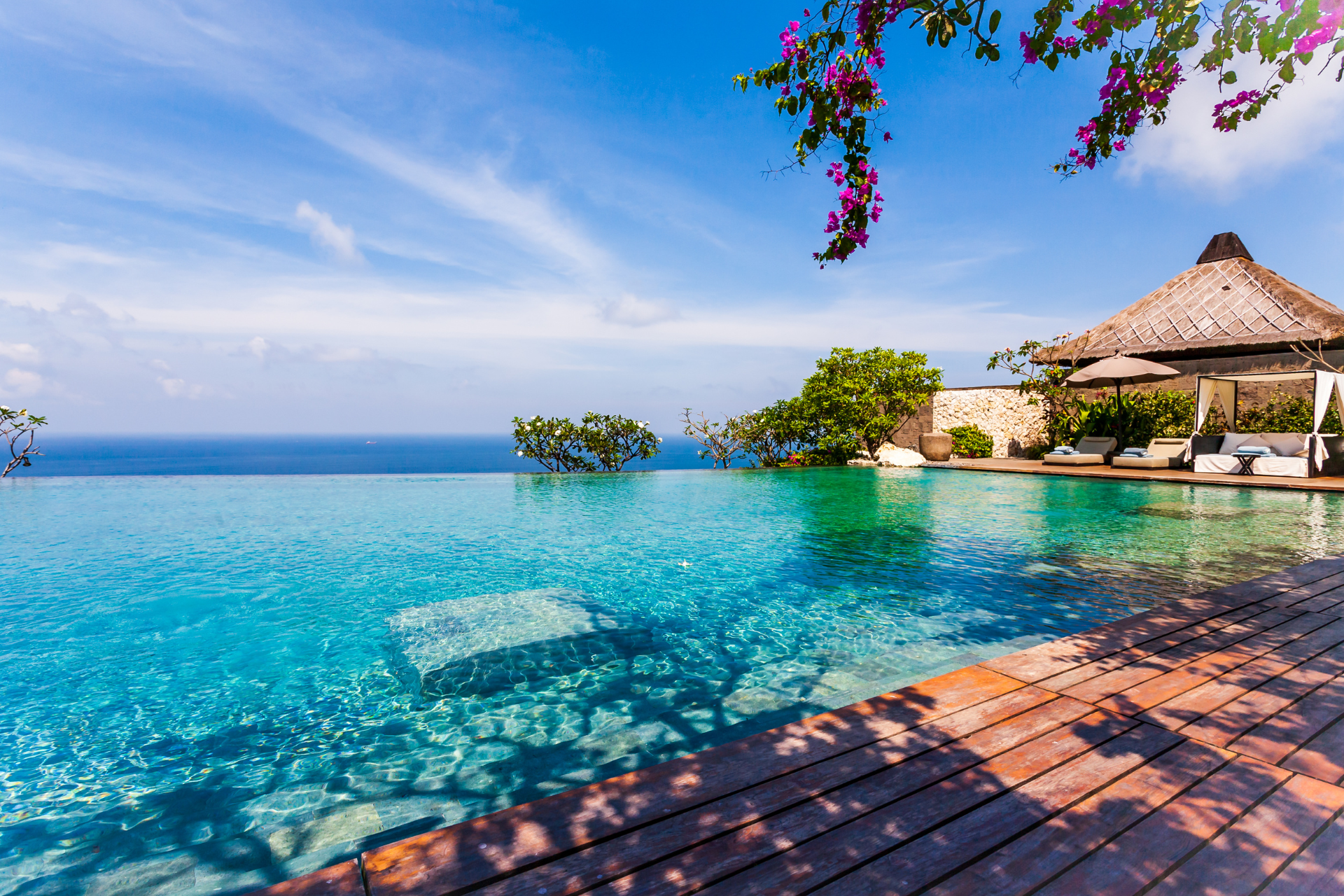 There is a swimming pool with a view of the ocean.