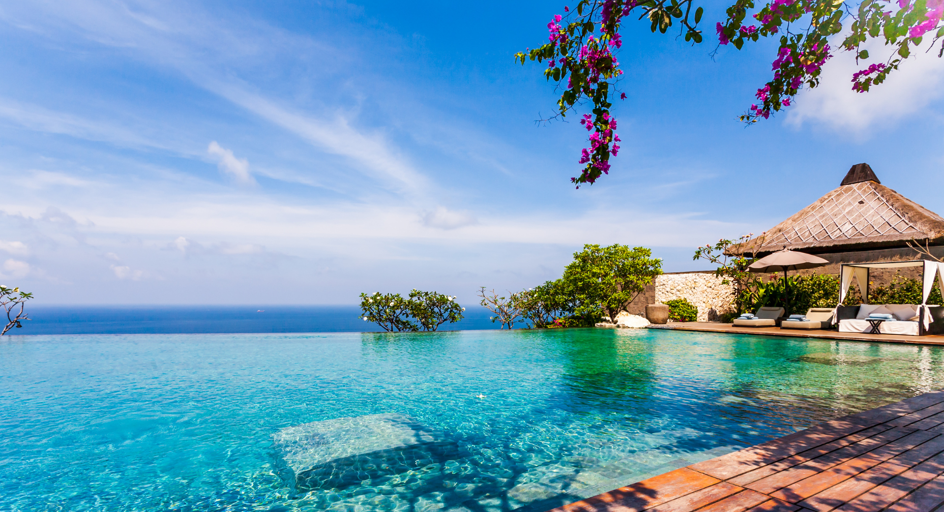 There is a swimming pool with a view of the ocean.