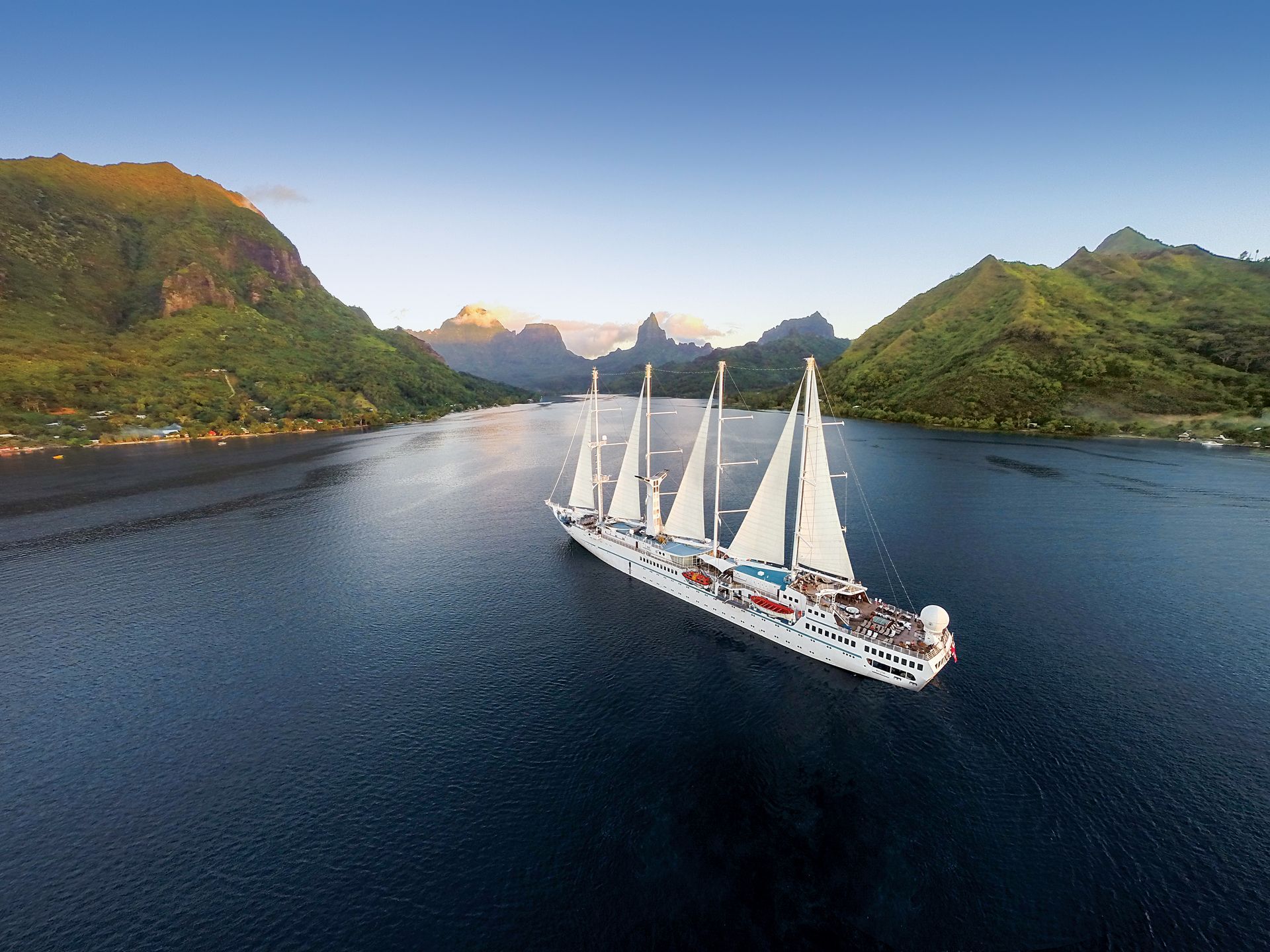 An aerial view of a large sailboat floating on top of a body of water.