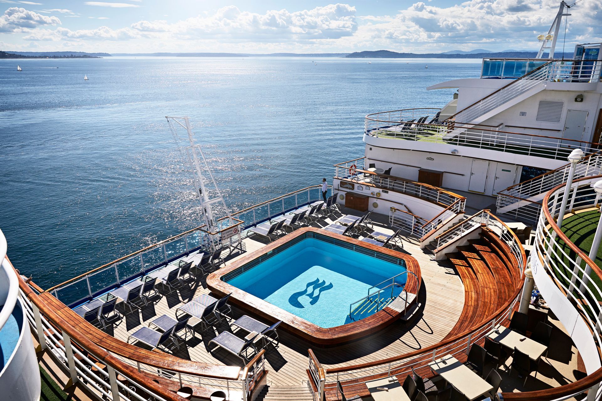 A large cruise ship with a large swimming pool on the deck