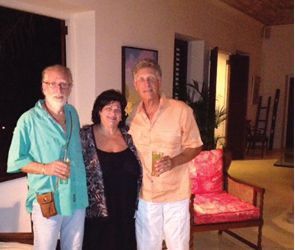 Three people are posing for a picture in a living room.