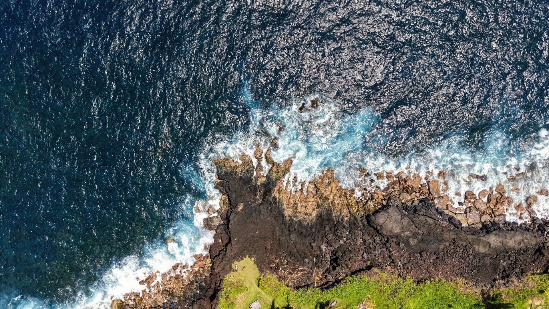 Pacific surf meets the rocky coastline below Koili Point’s oceanfront bluff in Papaikou.