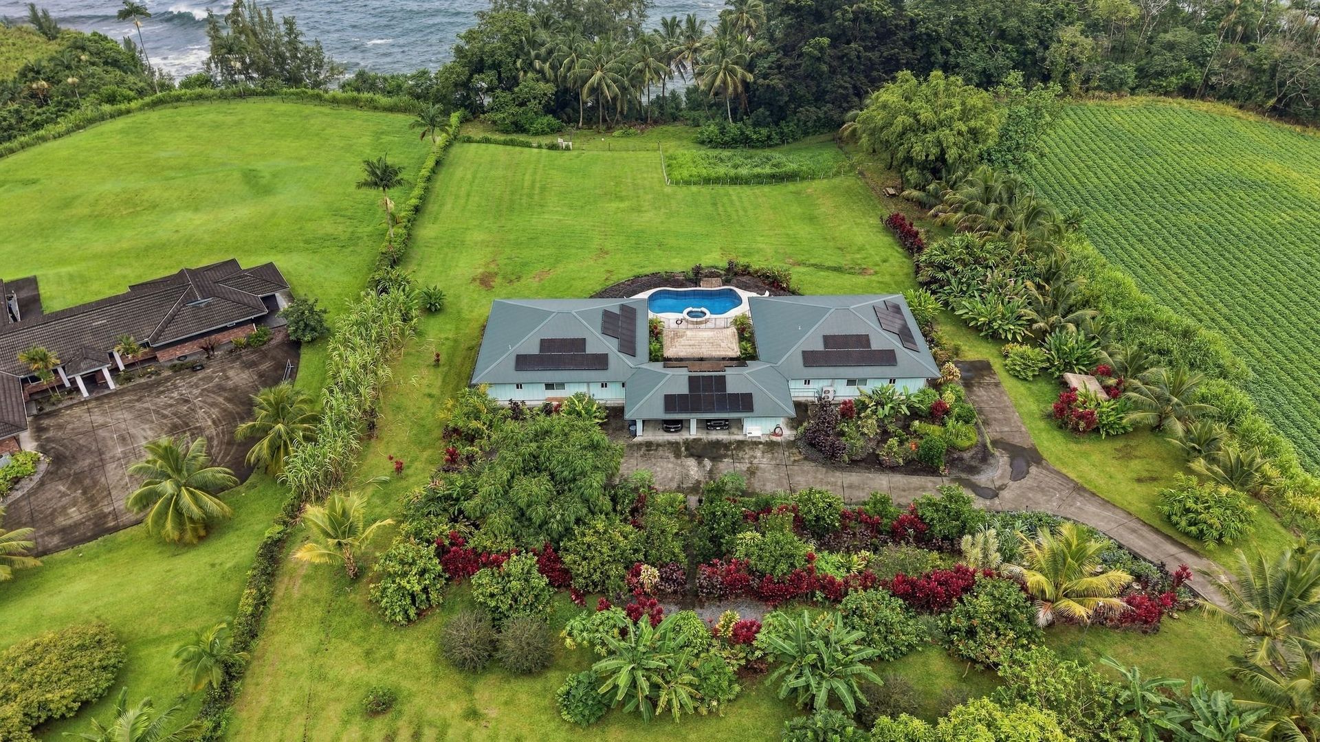 Hale Honu and Hale Koholā with their shared pool, solar roofs and tropical grounds at Koili Point.