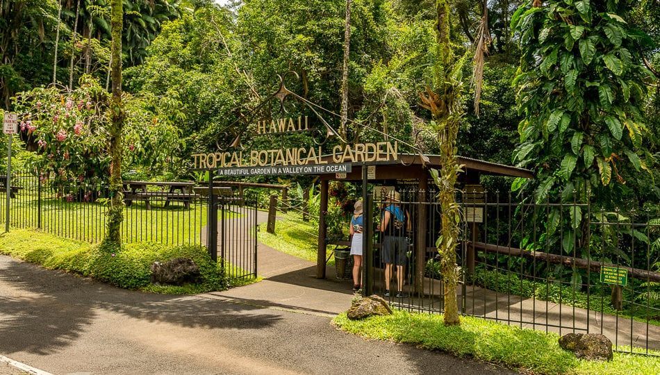 Entrance to Hawaii Tropical Botanical Garden, with people at the gate. Private oceanfront stay Big Island