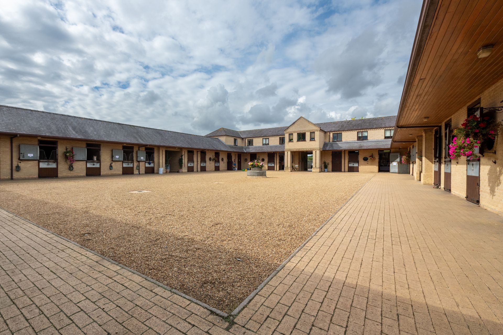 A large building with a brick courtyard in front of it.