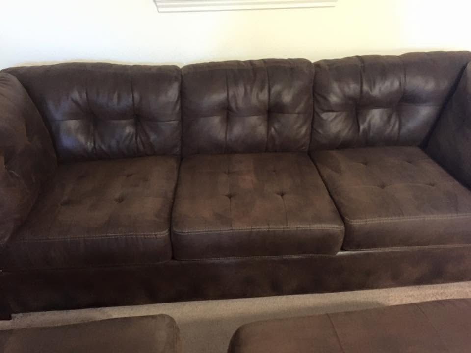 Brown leather sectional sofa against a light wall in a living room