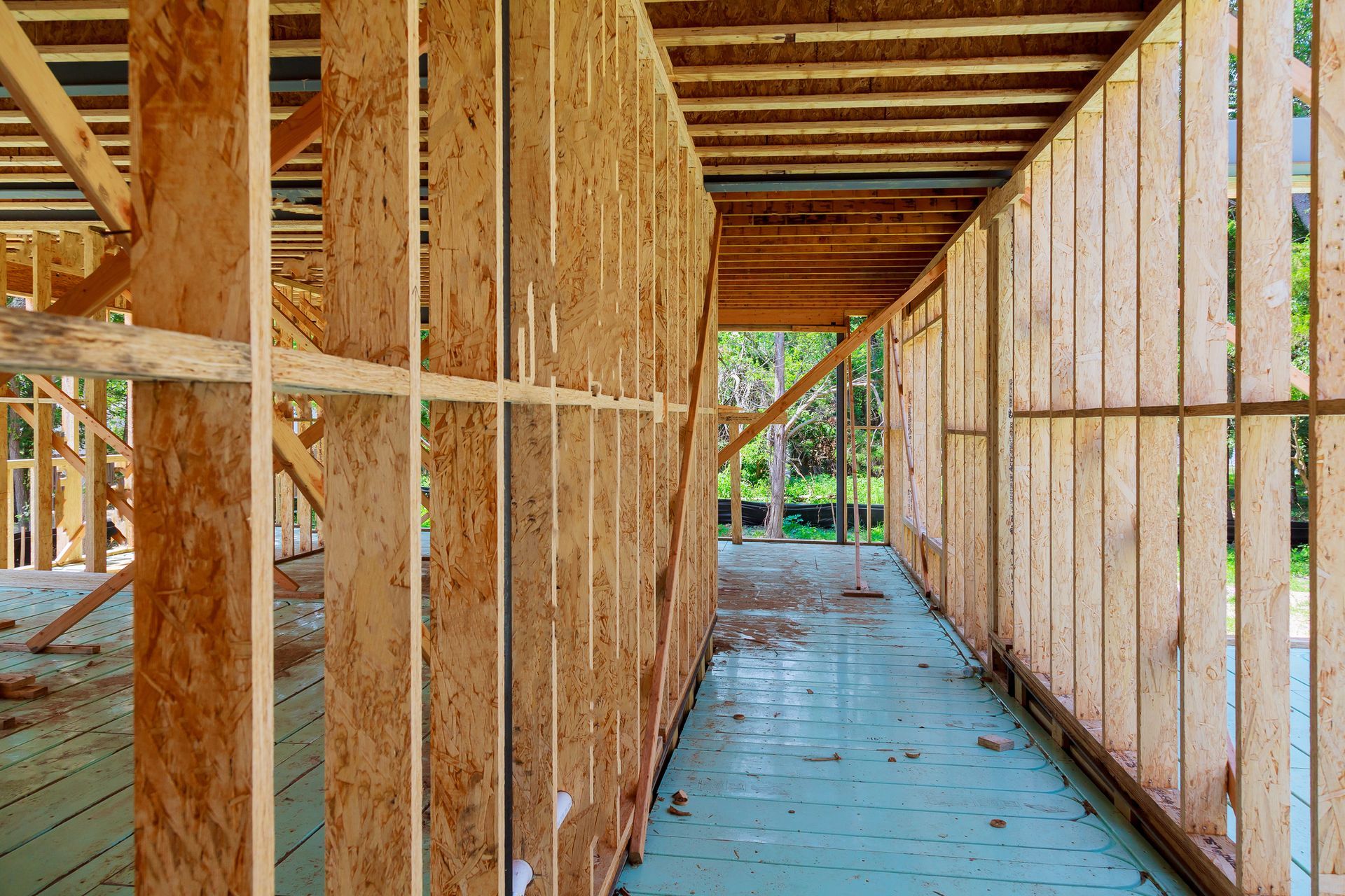 Wooden framework of a building under construction, with visible studs, beams, and insulation.