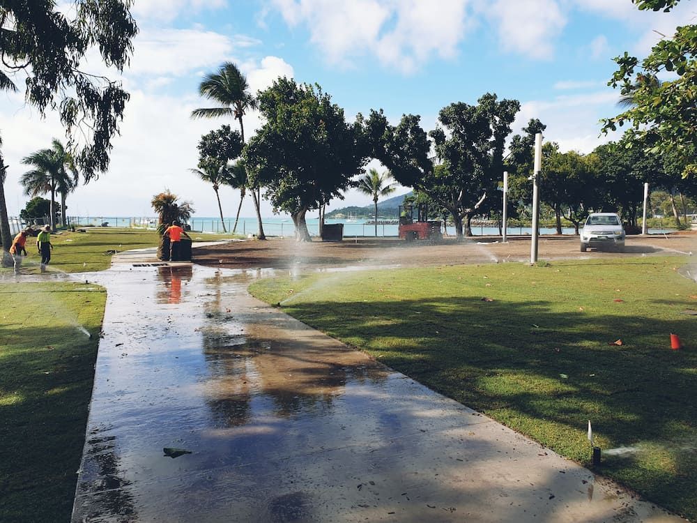 A Sprinkler Spraying Water On A Sidewalk In A Park — Marian Lawns In Proserpine, QLD