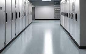 A long hallway filled with lots of cabinets in a server room.