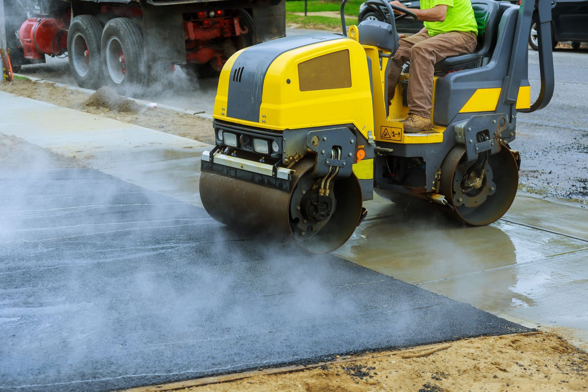 a man is driving a yellow roller on a road