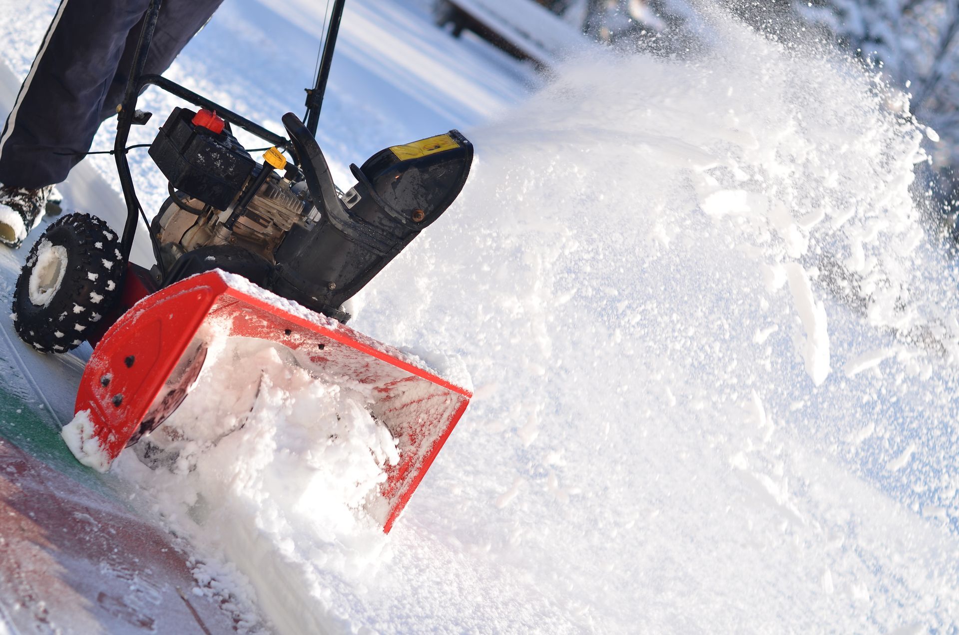 a person is using a snow blower to remove snow from a sidewalk