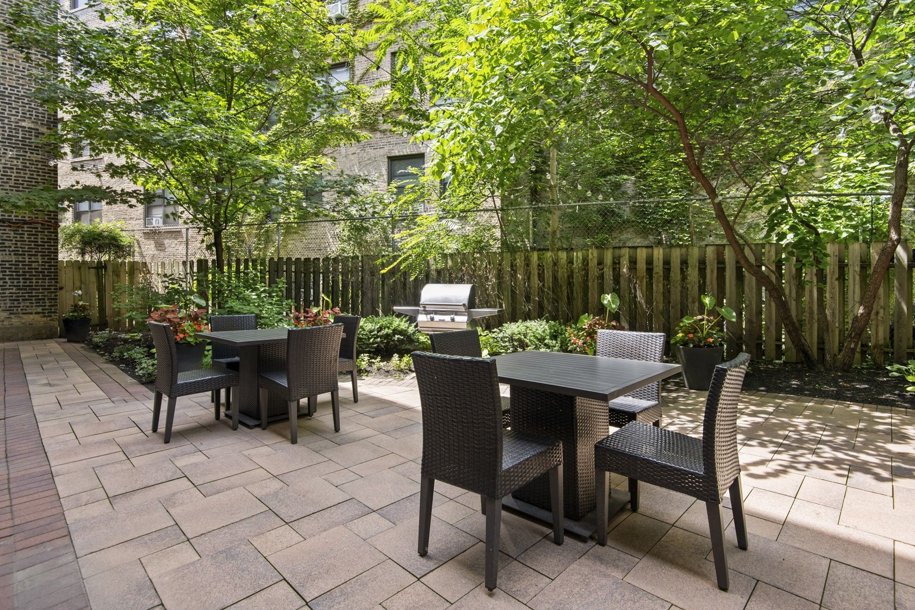 a patio with tables and chairs in a courtyard
