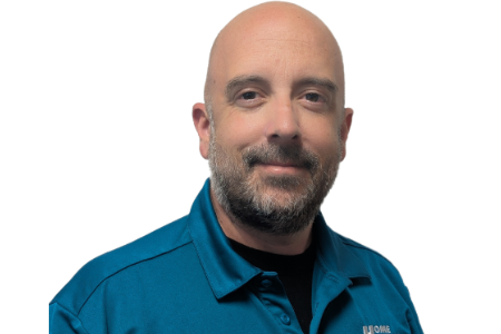 A person with a beard, wearing a teal collared shirt, smiles against a plain white background.