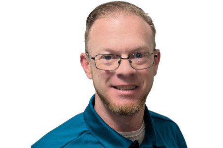 A person with a beard and glasses wearing a teal polo shirt smiles against a plain white background.