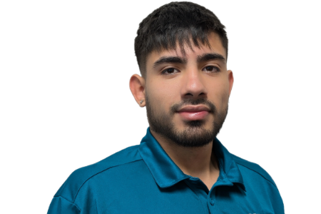 A person with short dark hair and a beard, wearing a dark teal collared shirt against a white background.