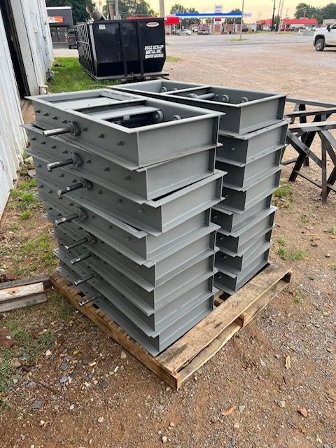 a stack of metal boxes sitting on top of a wooden pallet .