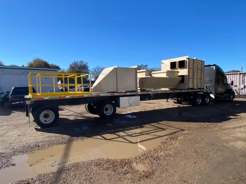 a trailer with a yellow railing is being pulled by a truck